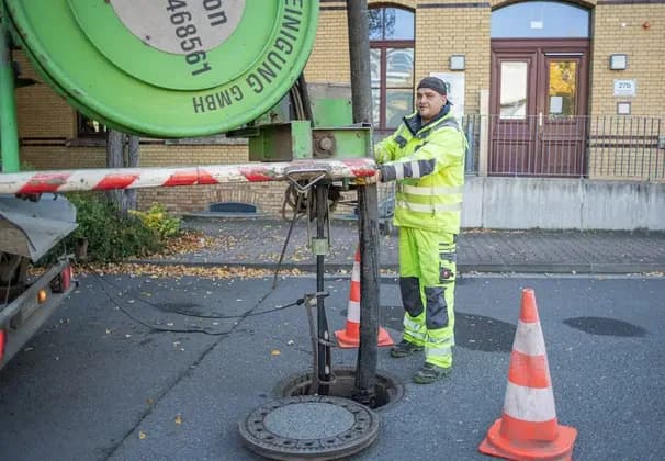 Techniker reinigt einen verstopften Küchenabfluss beim Kunden