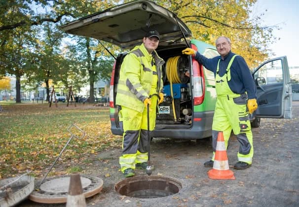 Besorgter Hausbesitzer spricht mit Techniker über Wasserschaden durch verstopftes Rohr