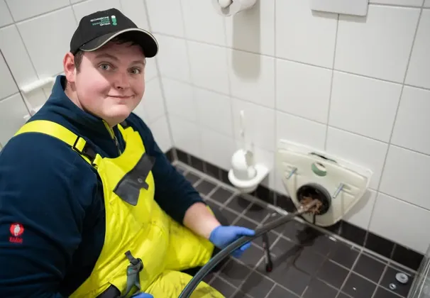 Techniker beruhigt Hausbesitzer bei einer verstopften Toilette